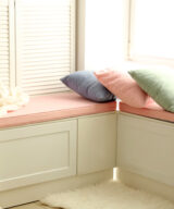 Pink bench cushions near window inside home