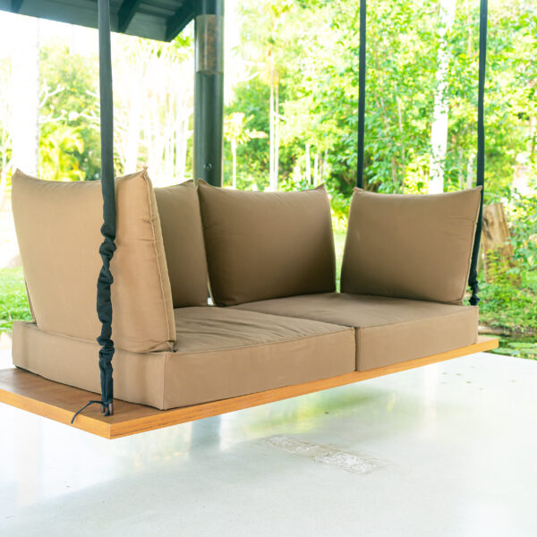 Covered outdoor sofa swing with taupe cushions in garden